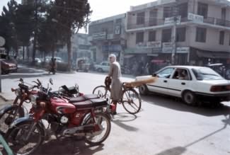 Képek Quettából - biciklista a parkoló járművek között